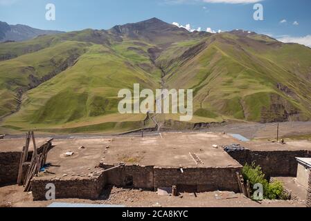 Xinaliq / Aserbaidschan - 8. Juli 2019: Landschaftlich reizvolle Aussicht auf Bergdorf mit schönen Kaukasus-Bergen im Hintergrund Stockfoto