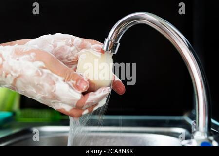 Waschen von Händen Reiben mit Seife Mann für die Winter-Grippe-Virus-Prävention, Hygiene zu stoppen Verbreitung von Keimen. Mann wäscht seine Hände mit Seife auf schwarz Stockfoto