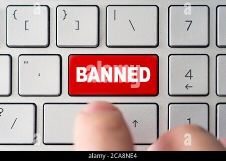 Admin verbietet den Benutzer. Rote Taste auf der Tastatur eines Notebooks mit der Aufschrift Banned. Konzept der Sperrung im Internet Stockfoto