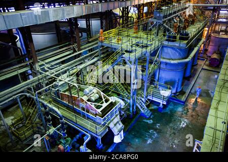 Akbakay/Kasachstan - April 23 2012: Pumpstation der Goldbergbau- und Verarbeitungsanlage. Arbeiter in blauem Schutzanzug und orangefarbenem Helm. Altynalmas com Stockfoto