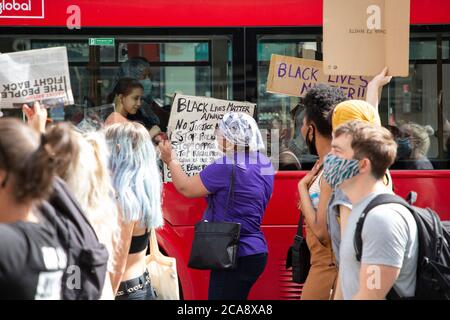 Passagiere in einem Bus schauen während einer Demonstration von Black Lives Matter, London, 2. August 2020 Stockfoto