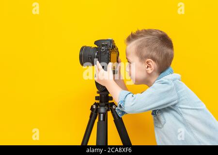 Kleiner Junge nimmt Video mit Digitalkamera auf Stativ Stockfoto