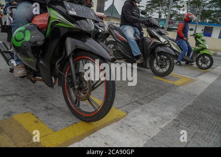 Malang, Ost-Java, Indonesien. August 2020. Lokale Behörde Motorrad stehen Gitter an der Ampel stoppen als Maß der physischen Distanzierung zur Kontrolle Covid-19 Coronavirus für die weitere Ausbreitung zu verhängen. (Bild: © Dicky BisinglasiZUMA Wire) Stockfoto