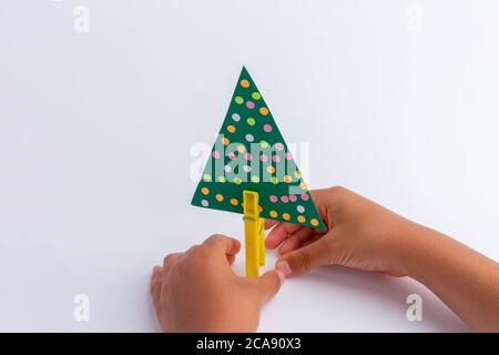 Kinderkreativität. Handwerk aus improvisierten Mitteln. Weihnachtsbaum Handwerk. Einfach und billig. Aktivität für das Kind. Kinder Hände Stockfoto