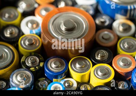 Nahaufnahme von positiven Enden entladener Batterien in verschiedenen Größen und Formaten, selektiver Fokus. Gebrauchte Batterie zum Recycling. Gefährliche Müllkonce Stockfoto