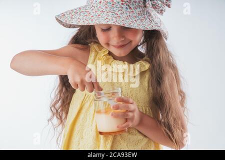 Schöne kleine Mädchen essen lecker Creme Dessert Porträt isoliert auf weißem Hintergrund Stockfoto