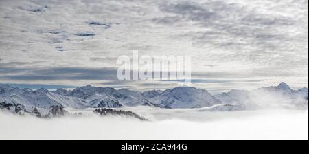 Schneebedeckte Berge mit Inversion Valley Nebel und Bäume in Nebel gehüllt. Panorama verschneite Winterlandschaft in Alpen, Allgau, Kleinwalsertal, Bayern Stockfoto