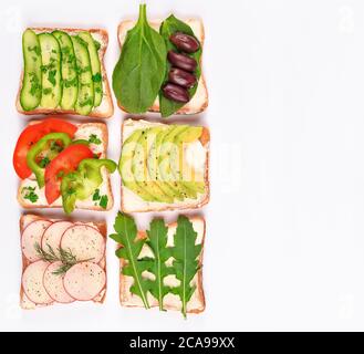 Set mit Toastbrot und verschiedenen veganen Belägen auf weißem Hintergrund, Draufsicht. Toasts mit Avocado, Spinat, Arugula und anderen Gemüsearten Stockfoto