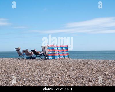 Aldeburgh, Suffolk, Großbritannien. August 2020. Die Menschen genießen den Kiesstrand an der Nordsee an einem warmen Sommertag mit einer steifen Brise, während der aktuelle heiße Zauber im Osten Englands weitergeht. Kredit: Julian Eales/Alamy Live Nachrichten Stockfoto