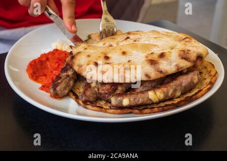 Cevapcici oder Cevapi, bosnische Gericht auf dem Grill zubereitet und mit Lepinja Brot serviert. Beliebtes Balkangericht. Stockfoto