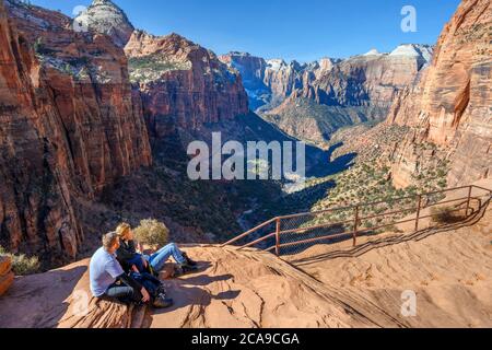 Familie sitzt auf einem Felsen am Canyon Overlook, Zion Canyon, Zion National Park, Utah, USA Stockfoto