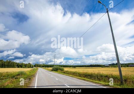 Leere Straße auf dem Land im Sommer, Finnland Stockfoto