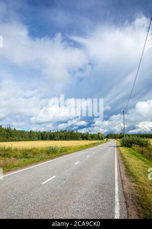 Leere Straße auf dem Land im Sommer, Finnland Stockfoto