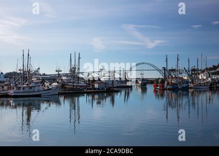 Boote im Hafen mit Yaquina Bay Bridge, Newport, Oregon Stockfoto