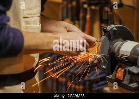 Nahaufnahme von Funken Holzsäge. Zugeschnittenes Foto von männlichen Holzarbeiter arbeiten an leistungsstarken Maschine Holz schneiden Stockfoto
