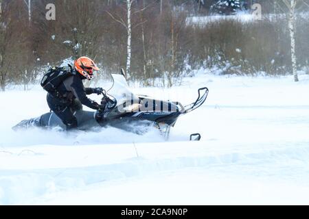 Teriberka, Russland - 24. Februar 2018: Mann in einem Sport Helm reitet ein Schneemobil Stockfoto