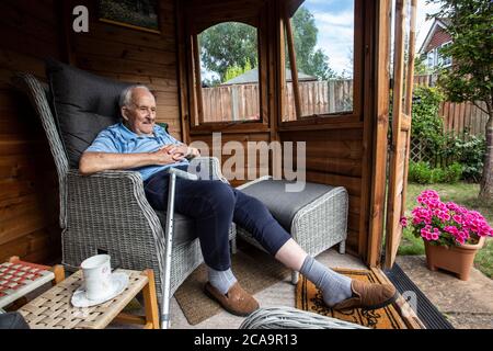 Ältere Paar in den 80ern genießen das warme Sommerwetter in ihrem Garten Sommerhaus, England, Vereinigtes Königreich Stockfoto