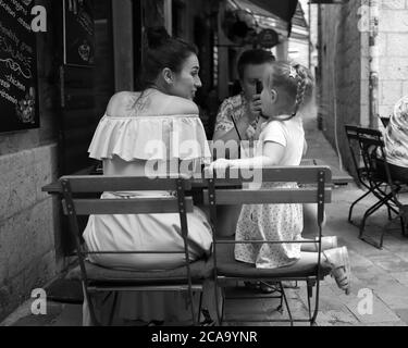 Montenegro, 22. September 2019: Ehepaar mit Tochter verbringt Zeit in einem Straßencafé in der Altstadt von Kotor (s/w) Stockfoto