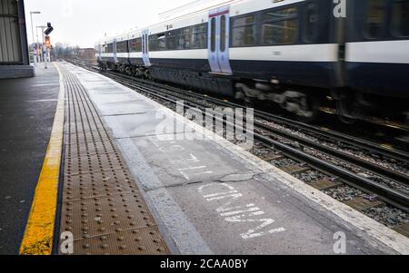 London, Vereinigtes Königreich - 01. Februar 2019: Nationaler Zug Ankunft am Bahnhof Lewisham an bewölktem Tag, beachten Sie den Schritt auf dem Bahnsteig geschrieben. Stockfoto