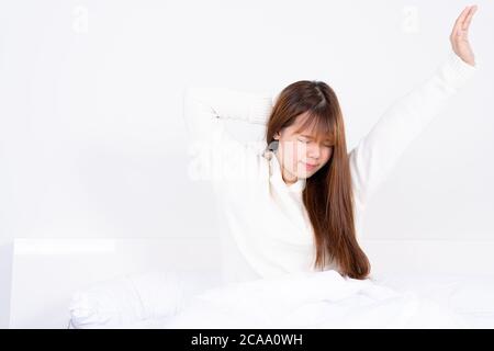Junge asiatische Frau Stretching im Bett nach dem Aufwachen aus dem guten komfortablen Bett. Healthcare Medical oder Alltag Konzept. Stockfoto