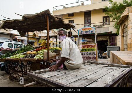 Der Mensch bemerkt, dass der Fotograf sein Bild auf dem Handwagen mitten auf dem Markt fotografiert Stockfoto