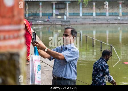 Mayiladuthurai, Tamil Nadu, Indien - Februar 2020: Ein indischer Mann nimmt ein Selfie am heiligen Tank des alten Hindu-Tempels in Vaitheeswaran Koil. Stockfoto