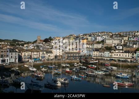 Am frühen Morgen Brixham Hafen malerische Aussicht. Blick auf den alten Hafen auf Häuser und Geschäfte über den Bootsliegeplätzen unten. Stockfoto