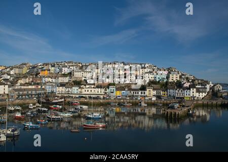 Am frühen Morgen Brixham Hafen malerische Aussicht. Blick auf den alten Hafen auf Häuser und Geschäfte über den Bootsliegeplätzen unten. Stockfoto