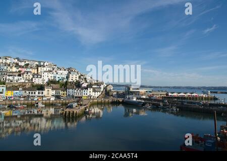 Am frühen Morgen Brixham Hafen malerische Aussicht. Blick auf den alten Hafen auf Häuser und Geschäfte über den Bootsliegeplätzen unten. Stockfoto