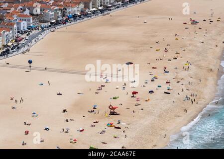 Hohe Sicht auf viele Menschen am Sand des Strandes in der Nähe der Stadt von oben gesehen, während eines sonnigen Sommertages Stockfoto