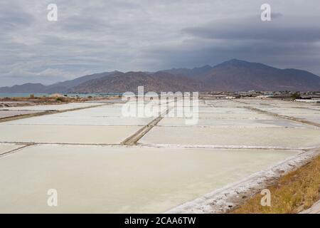 Natürliche Salzfelder Fabrik mit blauem Himmel an sonnigen Tagen im Norden von Mui Ne. Vietnam Küstenmotorradreise von Mui Ne nach Phan Rang Stockfoto