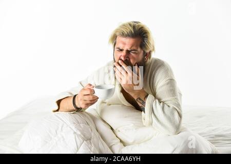 Der Körper wurde von wesentlichen Komponenten für eine gute Gesundheit und Energie beraubt. Start Tag mit gutem Kaffee. Gourmet-Espresso. Genießen Sie den morgendlichen Kaffee. Schöner Mann trinkt Kaffee. Reifer bärtiger Mann im Bett. Stockfoto