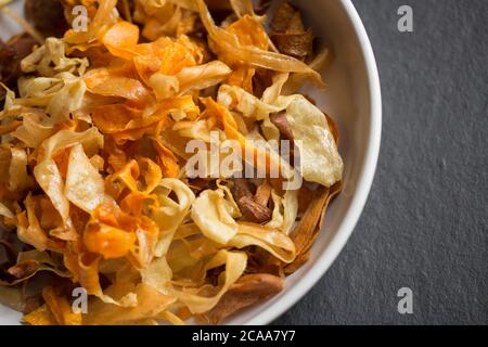 Eine große Schmorlvoll frittierter hausgemachter Chips aus Karotten, Pastinaken und Süßkartoffeln. Dorset England GB Stockfoto