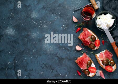 Bruschetta Set mit Prosciutto, Tomate und leichtem Käse für Wein. Draufsicht mit Kopierbereich. Stockfoto