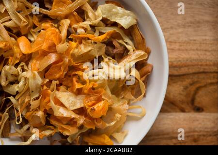 Eine große Schmorlvoll frittierter hausgemachter Chips aus Karotten, Pastinaken und Süßkartoffeln. Dorset England GB Stockfoto