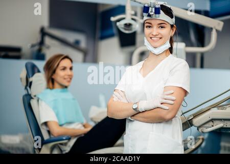 Porträt von positiv lächelnden Zahnarzt Frau in weißer Uniform Blick auf Kamera, sorgfältige Arzt in der Zahnarztpraxis, professionelle Arbeiter der Klinik Stockfoto