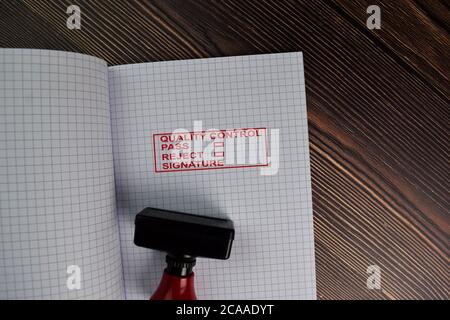 Roter Griff Gummi Stamper und Qualitätskontrolle, Pass, Reject und Signature Text isoliert auf dem Tisch. Stockfoto