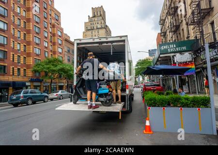 Arbeiter des Moped-Sharing-Unternehmens Revel entfernen ihr Inventar von den Straßen, die am Freitag, dem 31. Juli 2020, im Stadtteil Chelsea in New York zu sehen waren. Nach mehreren Todesfällen Revel angekündigt, dass es vorübergehend stillgelegt wird seine Operationen in New York, bis sie Fahrer Sicherheit und Rechenschaftspflicht Protokolle zu stärken. (© Richard B. Levine) Stockfoto