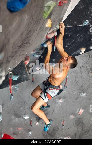 Athletischen männlichen Bergsteiger Ausbilder besitzen grundlegende belay Fähigkeiten, Gefühl frei zu klettern und Sichern andere Einrichtungen im Fels klettern. Stockfoto