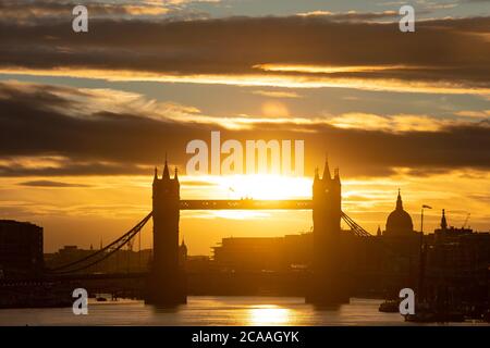 Die Sonne geht hinter der Tower Bridge und der Kuppel der St. Paul's Cathedral unter, wenn das warme Wetter anhält. Stockfoto