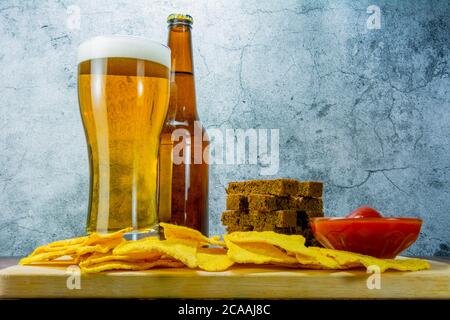 Bier und Snacks auf Steintisch legern. Cracker, Seitenansicht von Chips Stockfoto