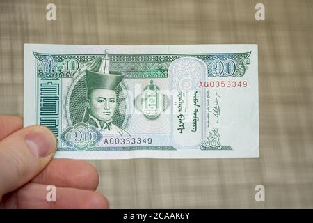 Nahaufnahme einer männlichen Hand mit mongolischer Tugrik-Banknote Stockfoto