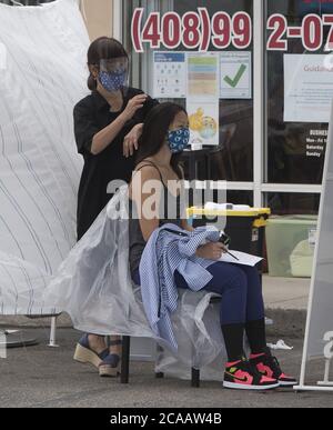 Cupertino, Usa. August 2020. Am Mittwoch, den 5. August 2020, schneidet eine Kosmetikerin außerhalb von Wonder Cuts auf El Camino Real in Sunnyvale, Kalifornien, die Haare einer Frau. Kalifornien versucht, mit der Coronavirus-Pandemie fertig zu werden, ohne in eine zweite Sperre zu gehen. Foto von Terry Schmitt/UPI Kredit: UPI/Alamy Live Nachrichten Stockfoto