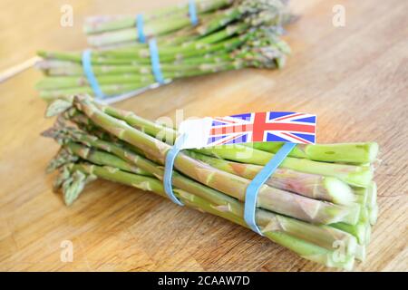 In der Saison Spargel mit einer britischen Union Jack Flagge auf Ein Holztisch Stockfoto