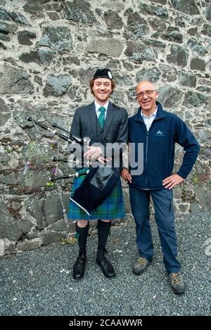 Scottish Borders Wanderprogramm. Vater und Sohn mit Dudelsack vor einem lokalen Pub, Peebles, Schottland Stockfoto