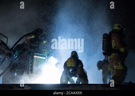 Feuerwehrmann mit Axt auf dem Dach. Nur für redaktionelle Zwecke. Stockfoto