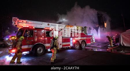 Leiter des Feuerwehrfahrzeugs vor dem Hausbrand. Nur für redaktionelle Zwecke. Stockfoto