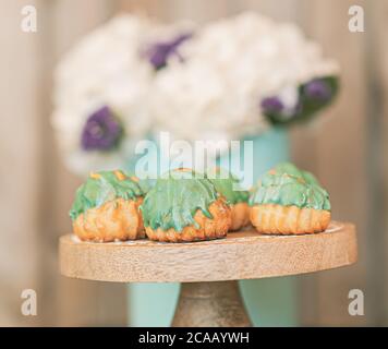 Pastellgrün Creme Puffs mit weißen Hortensien dekoriert. Stockfoto