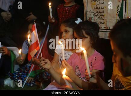 Gaza. August 2020. Palästinensische Kinder halten Kerzen und eine libanesische Flagge in der Stadt Rafah im südlichen Gazastreifen, am 5. August 2020, um Solidarität mit den Libanesen zu zeigen. Palästina drückte seine Solidarität mit dem Libanon aus, nachdem massive Explosionen Beirut erschüttert hatten. Quelle: Khaled Omar/Xinhua/Alamy Live News Stockfoto
