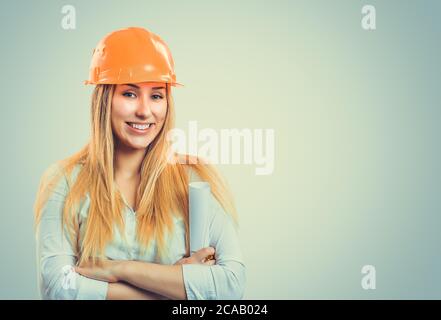 Professionelle content Frau in weißem Hemd Orange tragen, hardhat und Halten der Papierrolle Stockfoto
